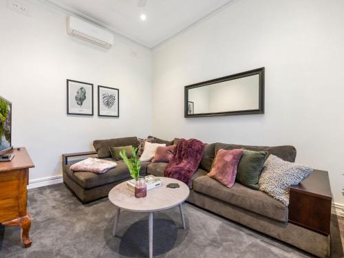a living room with a couch and a table at Walk to the MCG & AAMI Park - Free Late Checkout - Great location & Backyard in Melbourne