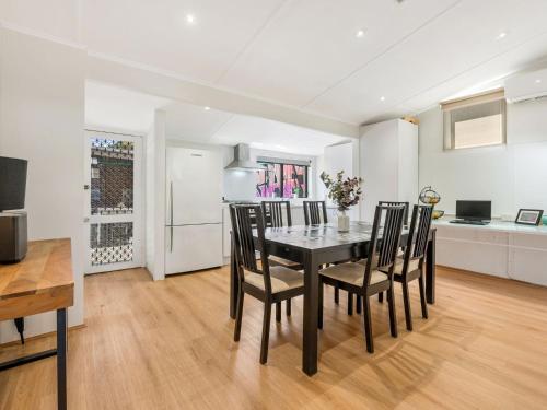 a kitchen and dining room with a table and chairs at Walk to the MCG & AAMI Park - Free Late Checkout - Great location & Backyard in Melbourne