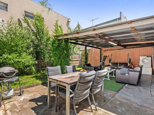 a patio with a table and chairs and a grill at Walk to the MCG & AAMI Park - Free Late Checkout - Great location & Backyard in Melbourne