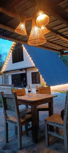 a wooden table and chairs under a blue roof at Isla Escondida Maceo Finca Hotel y Restaurante in Yolombó