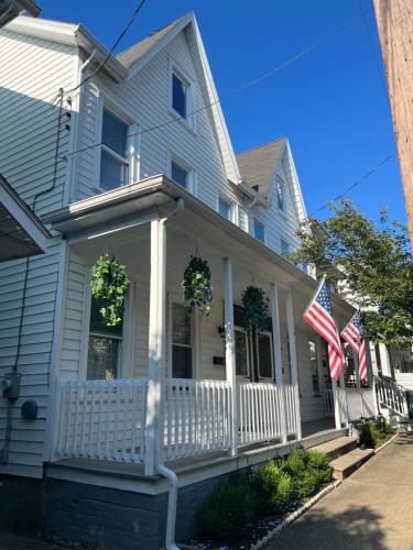 Uma casa branca com duas bandeiras americanas no alpendre. em Little France em Phillipsburg