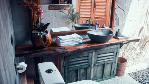 a bathroom with a wooden counter with a sink at JavaLO Villa Lombok in Sengkol
