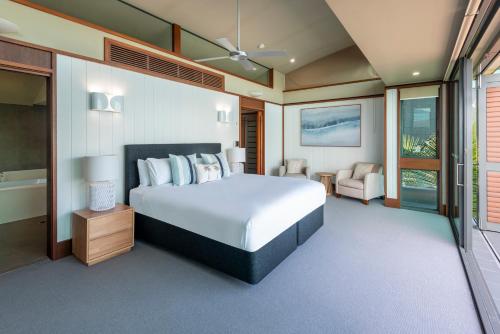 a bedroom with a large bed and a bathroom at Yacht Club Villas on Hamilton Island by HIHA in Hamilton Island