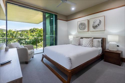 a bedroom with a bed and a living room at Yacht Club Villas on Hamilton Island by HIHA in Hamilton Island