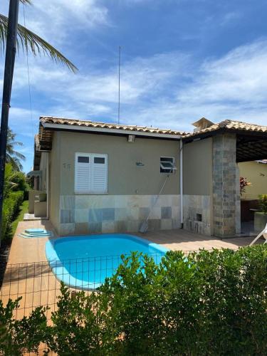 una casa con piscina frente a ella en Casa de praia 250 metros da praia, en Aracaju