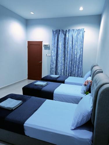 a room with two beds and a window at The Marak Village KB - Mini Homestay in Kota Bharu