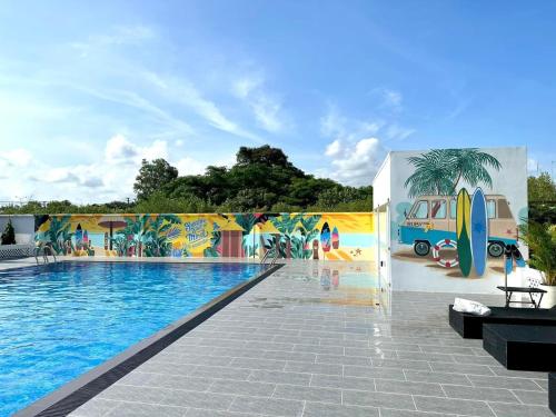 uma piscina com um mural de pranchas de surf numa parede em Ruby Homestay Cần Giờ 