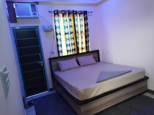 ein kleines Bett in einem Zimmer mit Fenster in der Unterkunft OYO Blue Dream Palace in Nārnaul