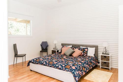 a bedroom with a bed and a chair at The Pavilion on Grossman's in Torquay