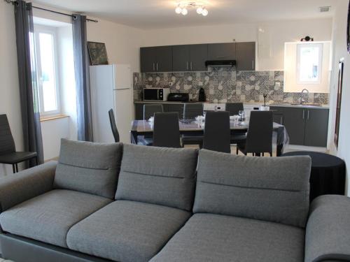 un salon avec un canapé et une cuisine dans l'établissement Maison au calme avec grand jardin et tout confort en Charente Limousine - FR-1-653-133, à Oradour-Fanais