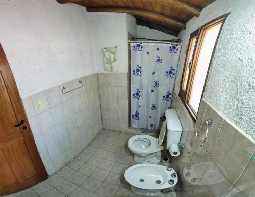 a bathroom with a toilet and a shower at Cabañas Budapest in Capilla del Monte