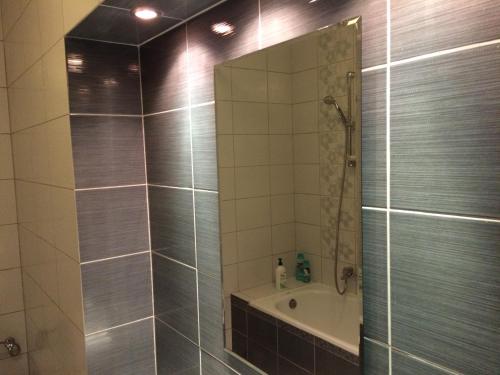 a bathroom with a shower with a mirror and a tub at Apartament Slupsk in Słupsk