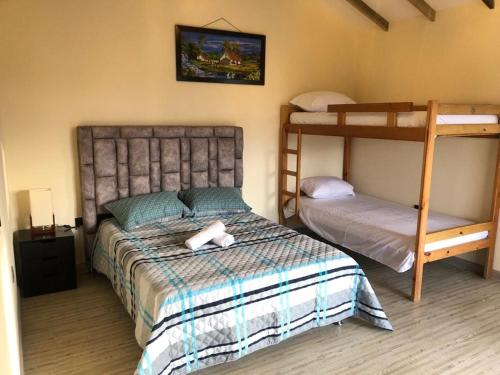 1 dormitorio con 2 literas y 1 cama en Cabañas Campestres Bosque Encantado, en Guatapé