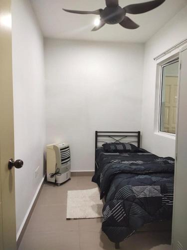 Schlafzimmer mit einem Bett und einem Deckenventilator in der Unterkunft Room for short stay with shared facilities in Seremban