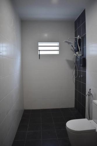 a white bathroom with a toilet and a shower at Room for short stay with shared facilities in Seremban