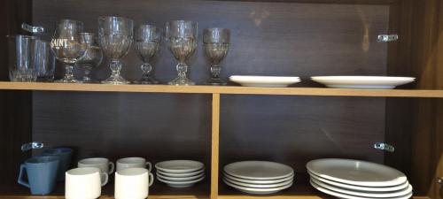 a wooden shelf with glasses and plates and dishes at Metropolitan Flats in Curitiba