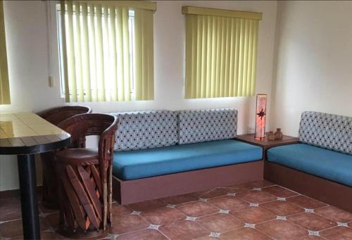 a waiting room with benches and a table and chairs at Suite Sofia Veracruz in Veracruz