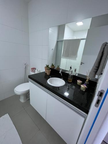 La salle de bains blanche est pourvue d'un lavabo et de toilettes. dans l'établissement Studio Nova Betãnia, à Mossoró