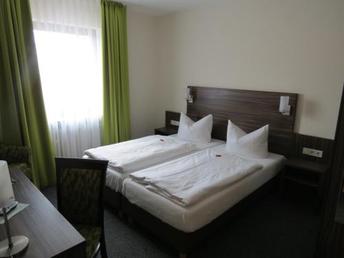 een hotelkamer met 2 bedden en een raam bij Hotel-Restaurant Zum Stern in Baumholder