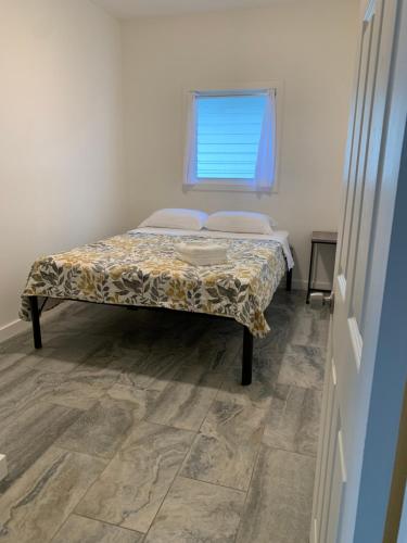 a bed in a room with a window at Downtown Hilo Apt L in Hilo