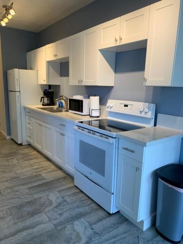 a kitchen with white appliances and white cabinets at Downtown Hilo Apt L in Hilo