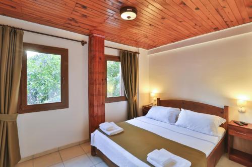 a bedroom with a bed with a wooden ceiling at Zinbad Hotel Kalkan in Kalkan