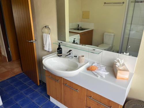 a bathroom with a sink and a mirror at Happy Dogs Cottage Margaret River in Margaret River Town