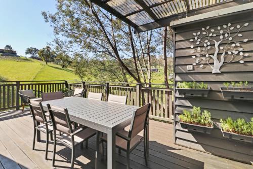 a patio with a table and chairs on a deck at Goughs Hideaway in Goughs Bay