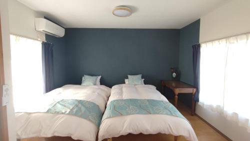 大川的住宿－Okawaya - Vacation STAY 49372v，卧室设有两张床铺和蓝色的墙壁