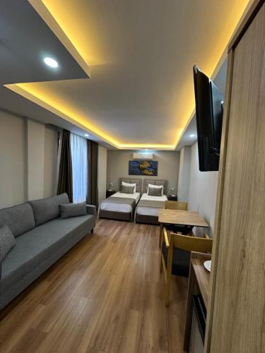 Sala de estar con sofá, cama y TV en Marista Pansiyon en Estambul