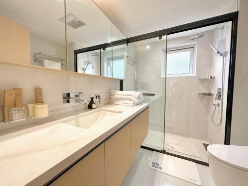 a bathroom with a glass shower and a sink at ZHome-Modern 3 bedrooms apartment - near NanJing Road in Shanghai