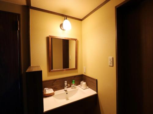 a bathroom with a sink and a mirror at Yakushidaira Akanejyuku in Matsumoto