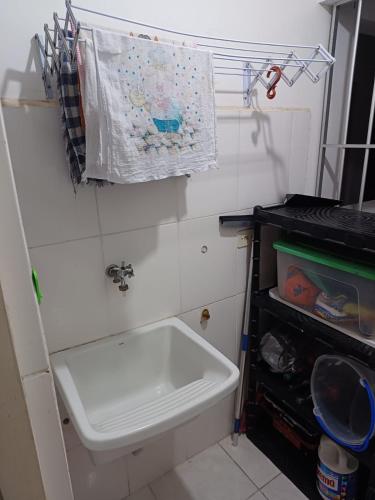 een badkamer met een wastafel en een handdoek aan de muur bij Apartamento encantador 22 in Ubatuba