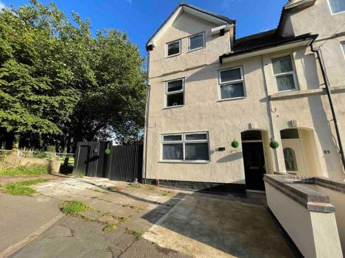 una casa di mattoni con una porta nera su una strada di 3- Lovely 1 Bed Apartment extra sofa bed-West Midlands 