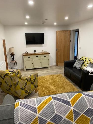 a living room with a couch and a tv at The Lions Den flat at the red lion public house. in Newbridge