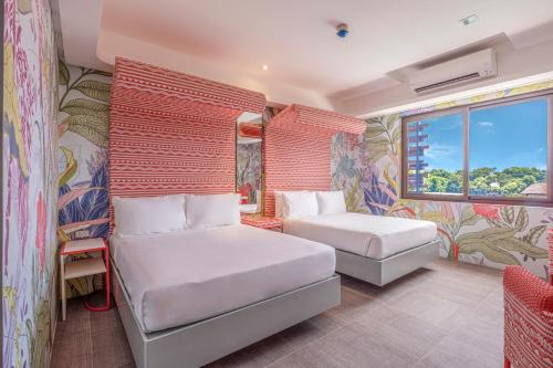 a hotel room with two beds and a window at Astoria Palawan in Puerto Princesa City