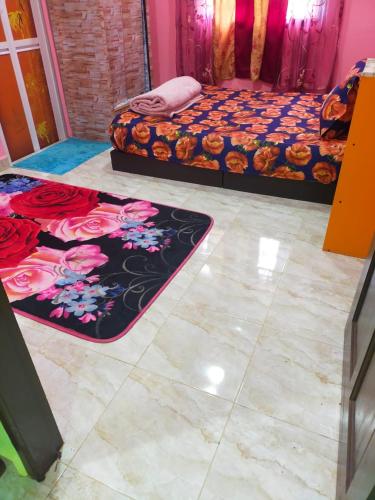 a bedroom with two beds and two rugs on the floor at ABAH HOMESTAY, MANIR, KUALA TERENGGANU (HOMESTAY A) in Kuala Terengganu