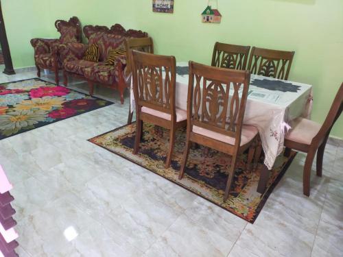 a dining room with a table and chairs and a couch at ABAH HOMESTAY, MANIR, KUALA TERENGGANU (HOMESTAY A) in Kuala Terengganu