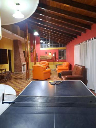 mesa de ping pong en la sala de estar con muebles de color naranja en Departamento Avenida in 