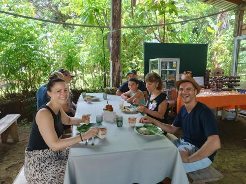 a group of people sitting around a table eating food at Cabaña blue jeans in San Ramón