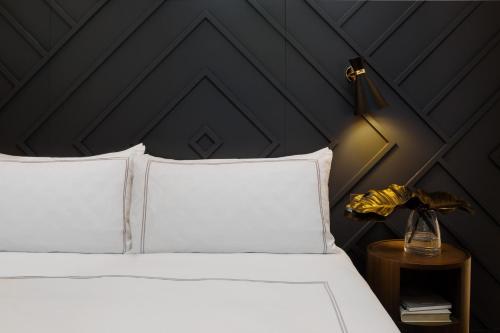 a bedroom with a bed with a black wall at West Hotel Sydney, Curio Collection by Hilton in Sydney
