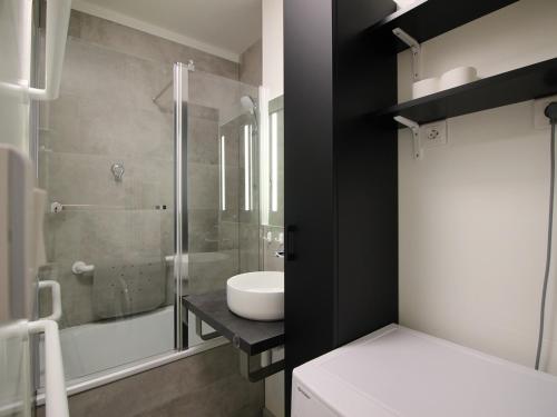 une salle de bain avec un lavabo et une douche en verre dans l'établissement Mont-Dore: 4 pers, proche centre, WIFI, parking, T2 au calme - FR-1-608-253, à Le Mont-Dore