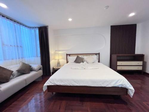 a bedroom with a large bed and a couch at 市中心Ruam精品别墅 in Bang Kapi