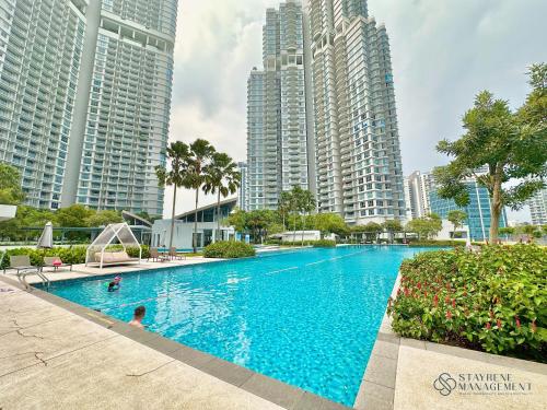 a swimming pool in the middle of some tall buildings at Teega Residence By Stayrene in Nusajaya