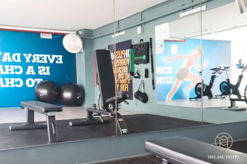 a gym with exercise equipment and a mirror at The Aru Hotel at Aru Suites in Kota Kinabalu