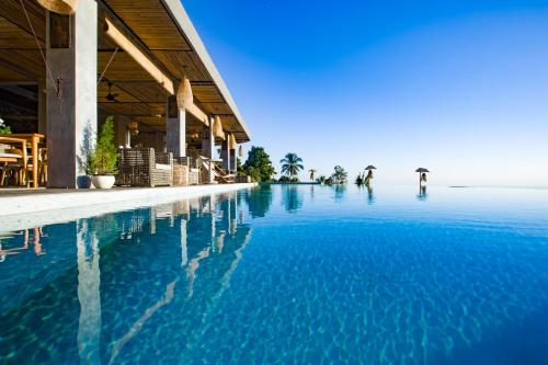 uma piscina ao lado de um edifício com água azul em Maha Hills Resort Lovina em Lovina