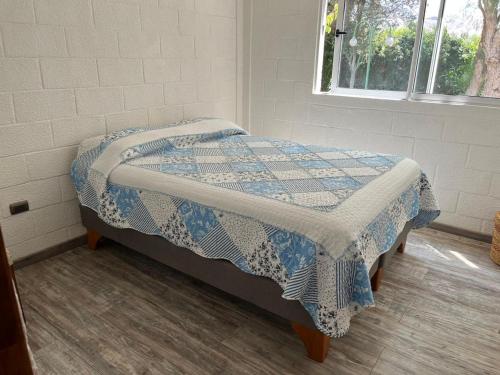 a bedroom with a bed with a blue and white quilt at Cómodo y lindo departamento en el centro de vicuña in Vicuña