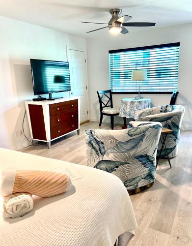 a living room with two chairs and a television at Organic Beach Retreat in Daytona Beach