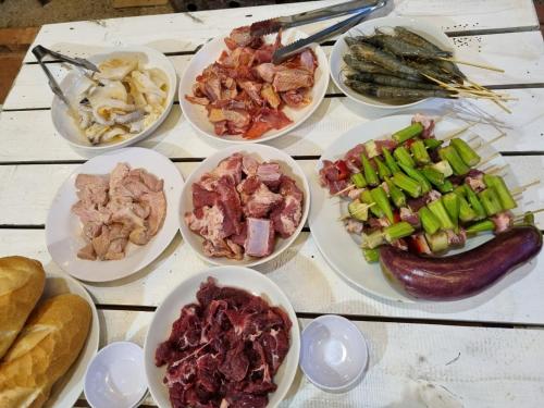 a table topped with plates of different types of food at Homestay Vườn Trái Cây Nhiệt Đới VÔ ƯU GARDEN in Bao Loc