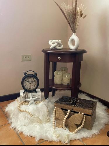a room with a table with a clock and a box at Paradise Island in Isabela